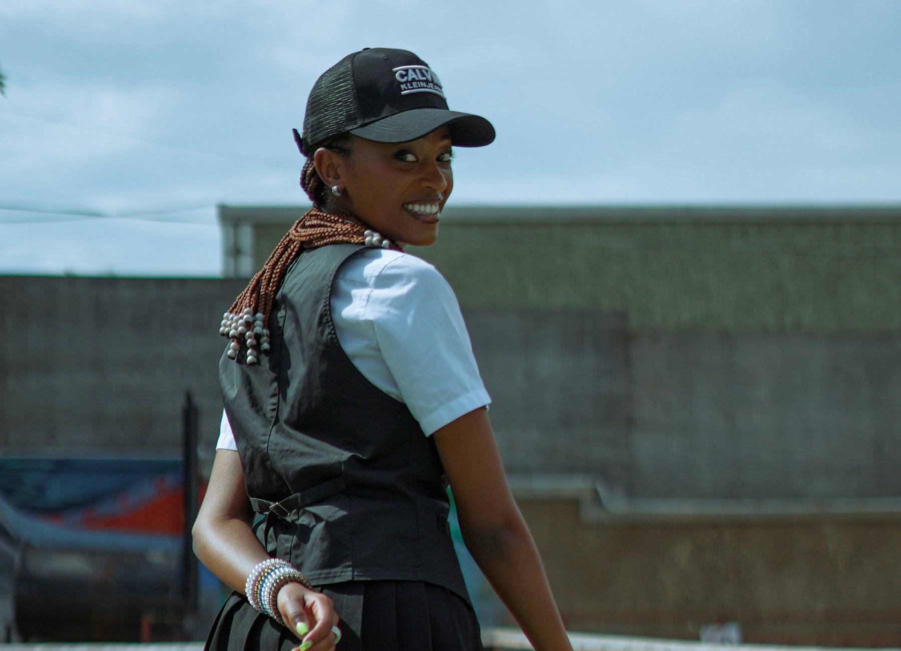 Tenista sorrindo na quadra, olhando por cima do ombro